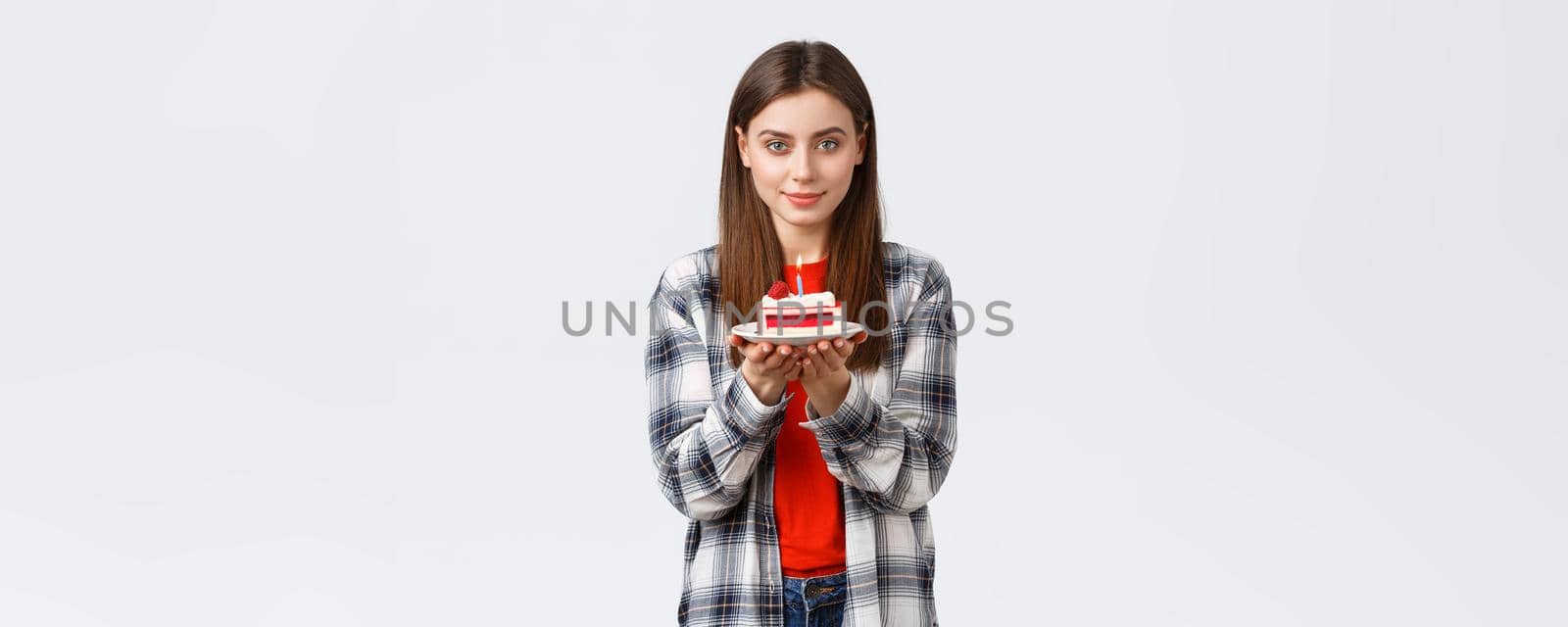 People lifestyle, holidays and celebration, emotions concept. Dreamy gorgeous young woman celebrate her birthday, holding b-day cake with lit candle, smiling kind at camera.