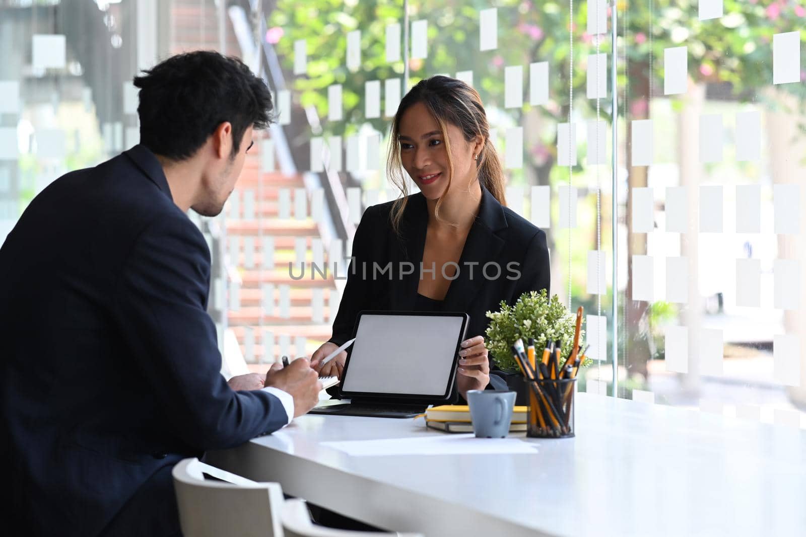 Experienced businesswoman explaining new business strategy to her business partner. by prathanchorruangsak