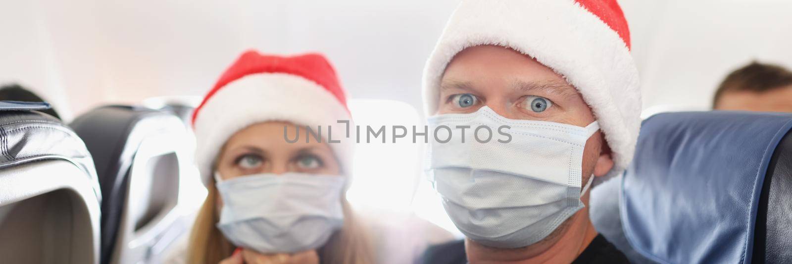 Portrait of couple tired of strong restrictions and need to wear face mask on board. Woman roll her eyes and feel annoyed. Virus, new year, delayed concept