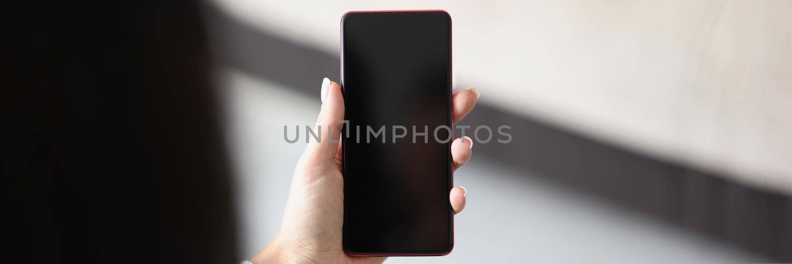 Close-up of woman hold smartphone with locked or turned off black screen. Mobile phone doesnt work, useless device. Mockup, technology concept. Copy space