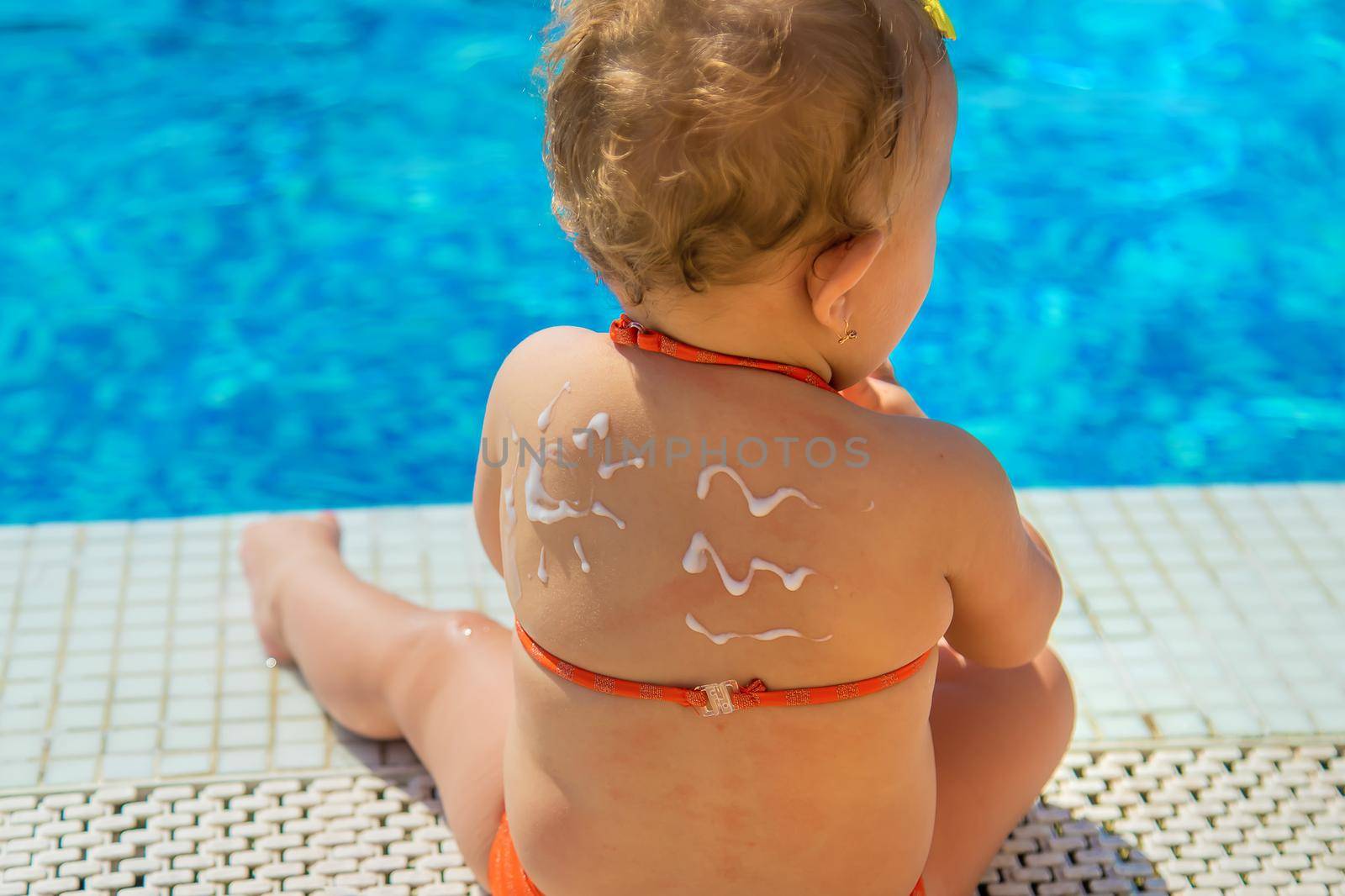 Sunscreen on the back of the child. Selective focus. Kid.