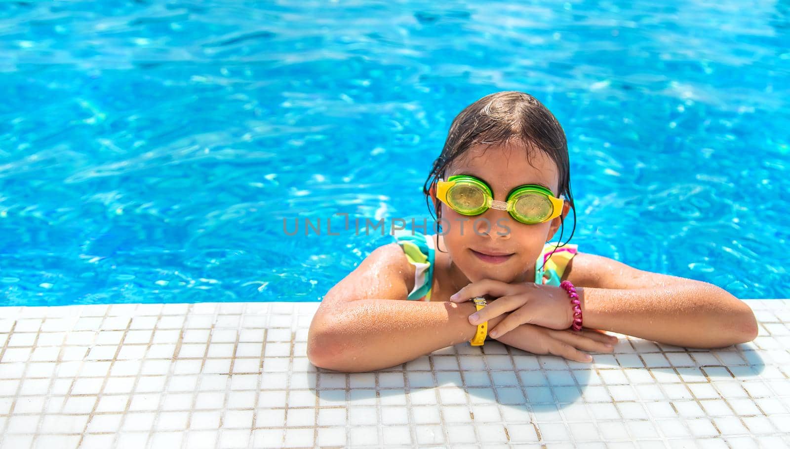 A child with glasses dives into the pool. Selective focus. Kid.