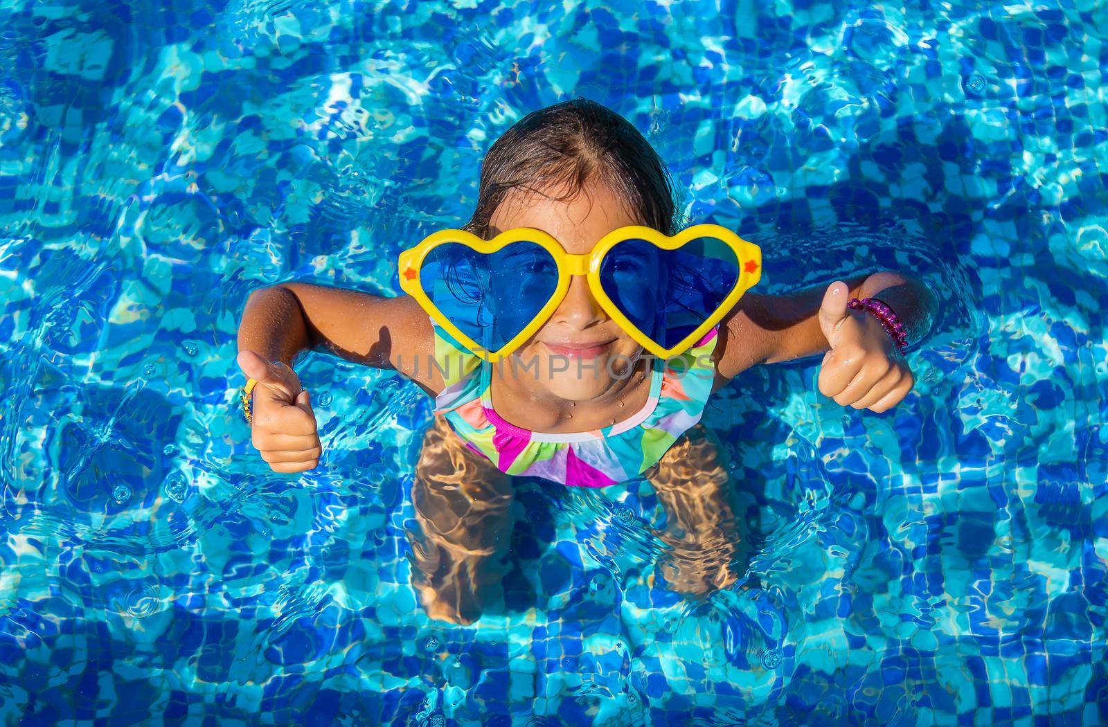 Child in the pool wearing big glasses. Selective focus. Kid.