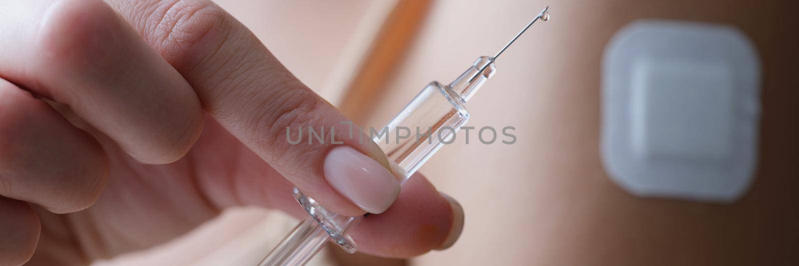 Woman holding syringe filled with medicine liquid and patch on arm by kuprevich