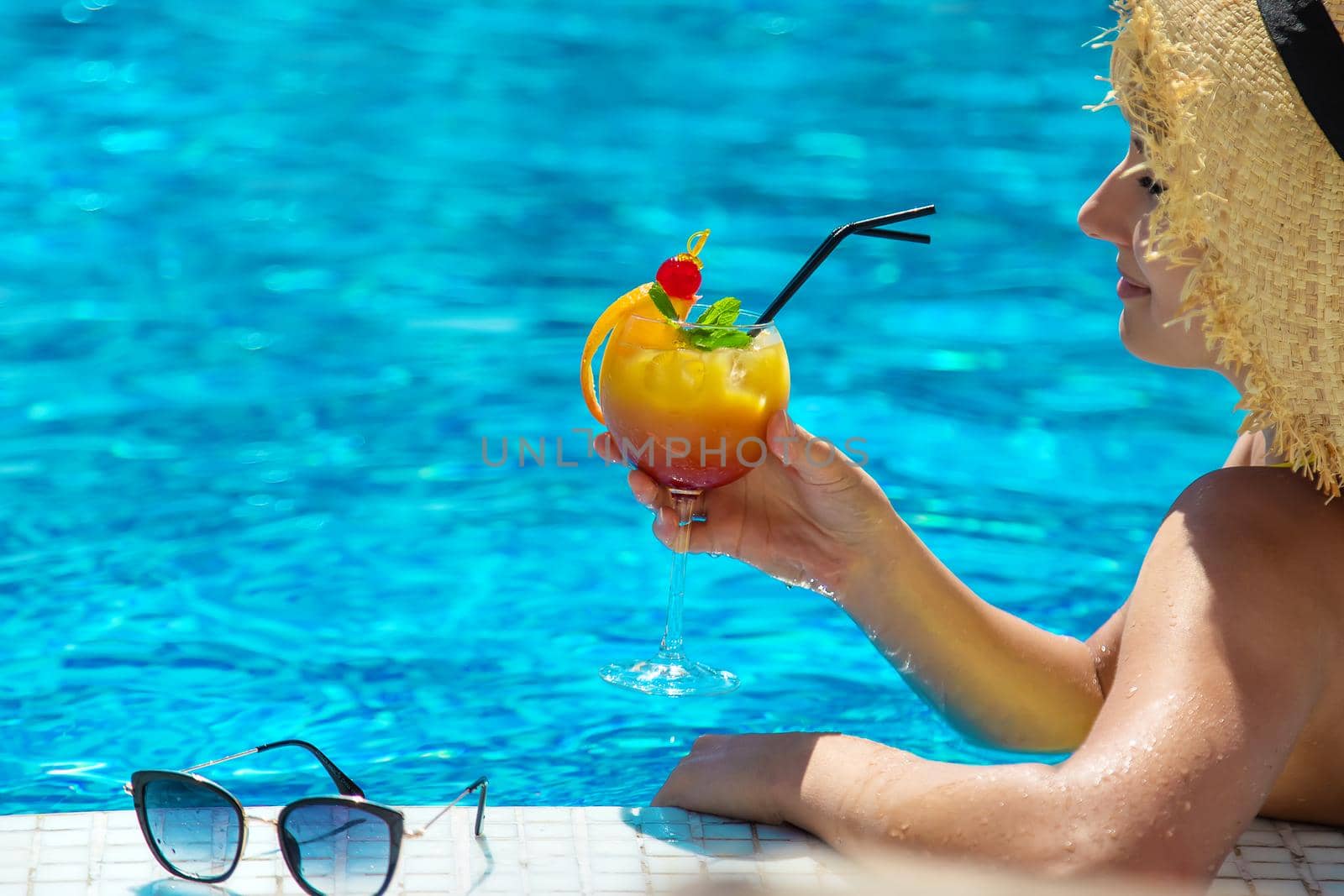 Woman with cocktail near the pool. Selective focus. Drink.