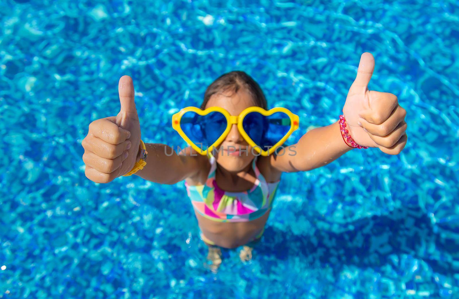 Child in the pool wearing big glasses. Selective focus. Kid.