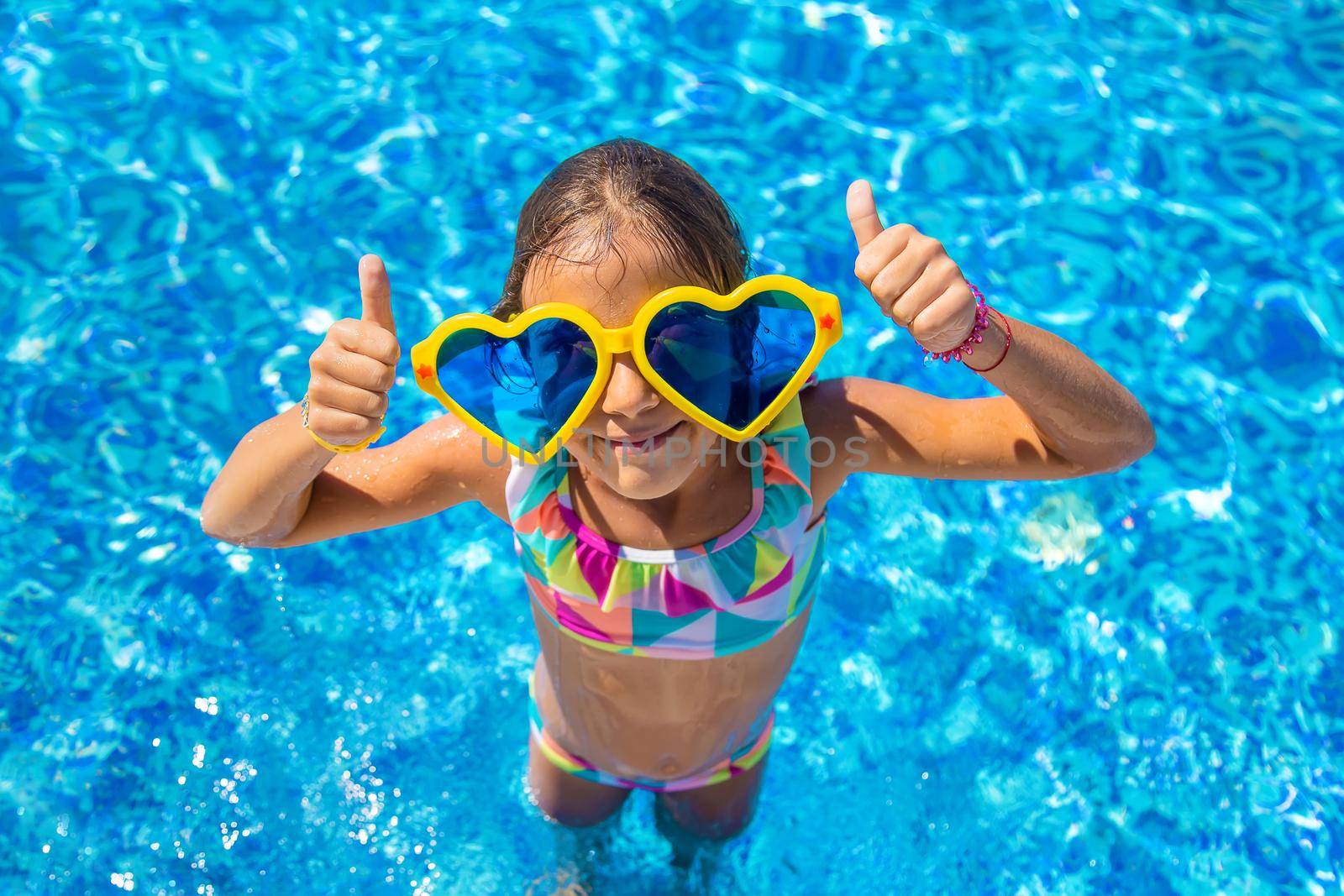 Child in the pool wearing big glasses. Selective focus. Kid.