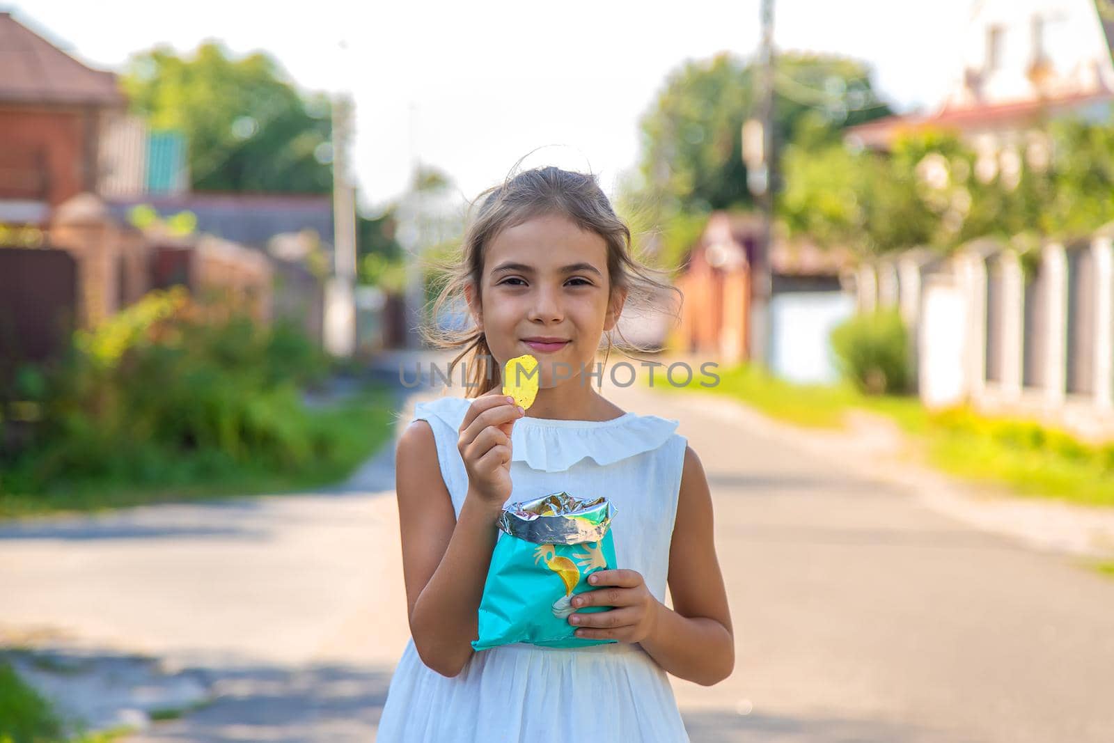 The child is eating chips. Selective focus. Kid.