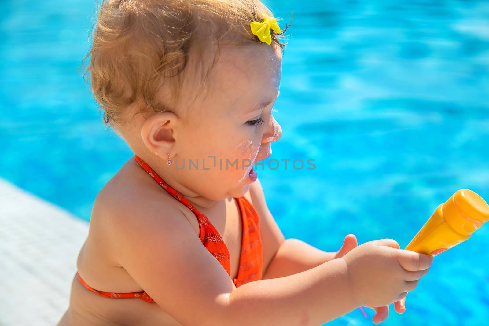 Child with sunscreen on her face. Selective focus. Kid.