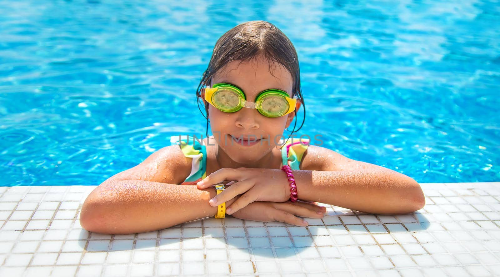 A child with glasses dives into the pool. Selective focus. Kid.