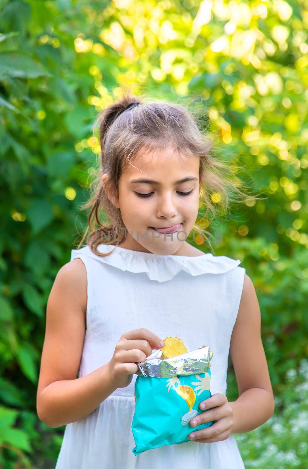 The child is eating chips. Selective focus. Kid.