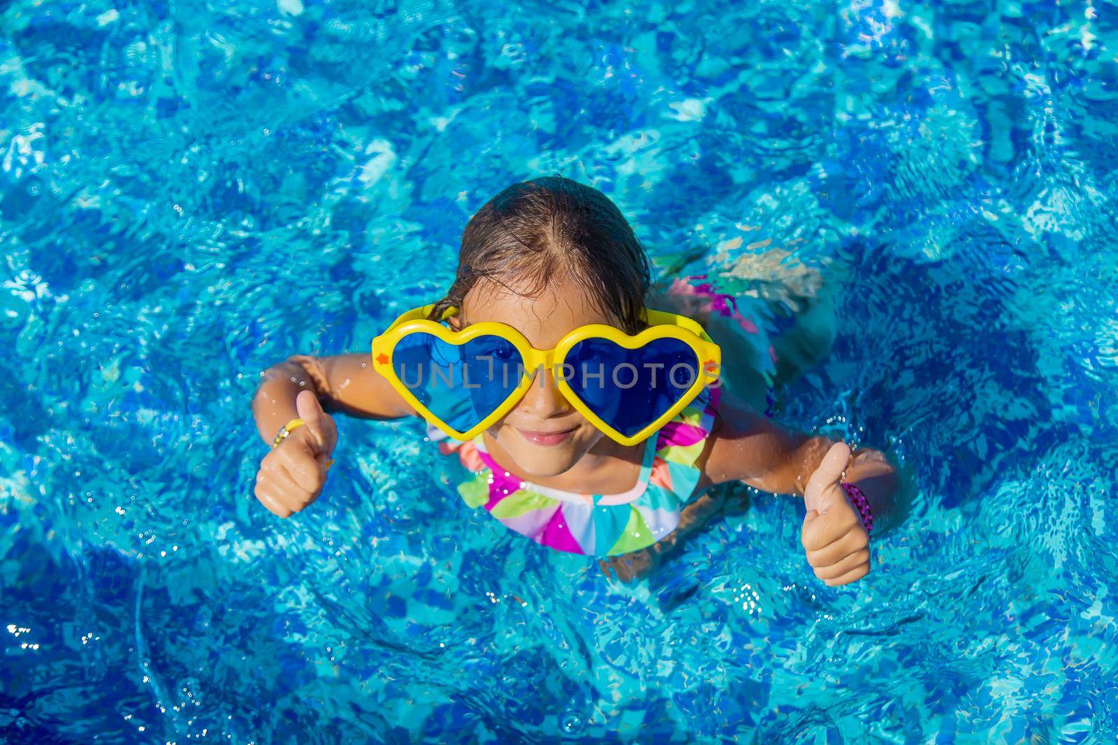 Child in the pool wearing big glasses. Selective focus. Kid.