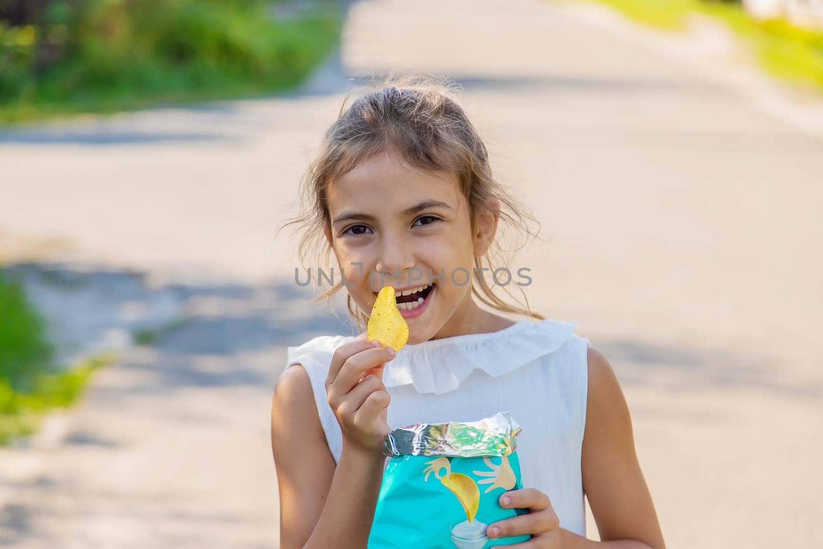 The child is eating chips. Selective focus. Kid.
