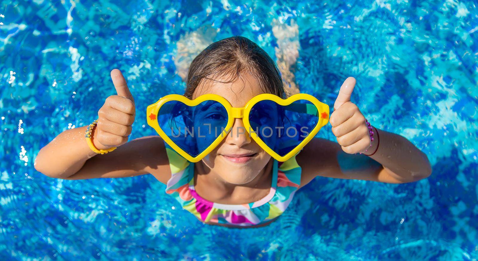 Child in the pool wearing big glasses. Selective focus. Kid.