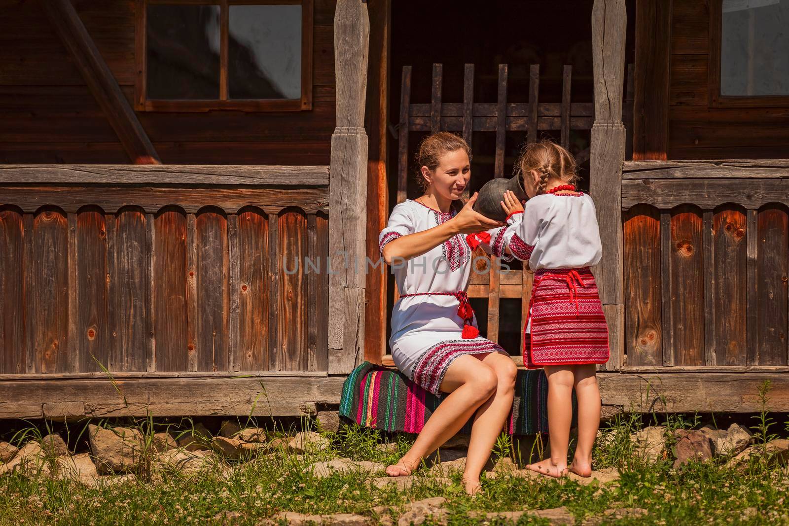 mother with daughter and a jug from which they drink milk