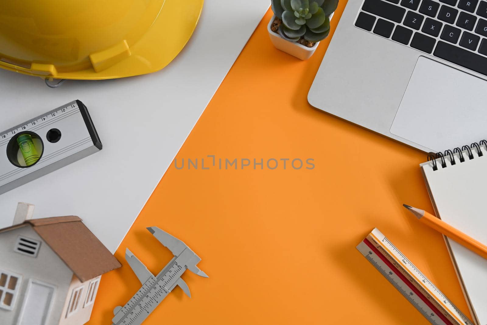 Architect workplace with laptop, helmet and some mechanical tools. Top view.