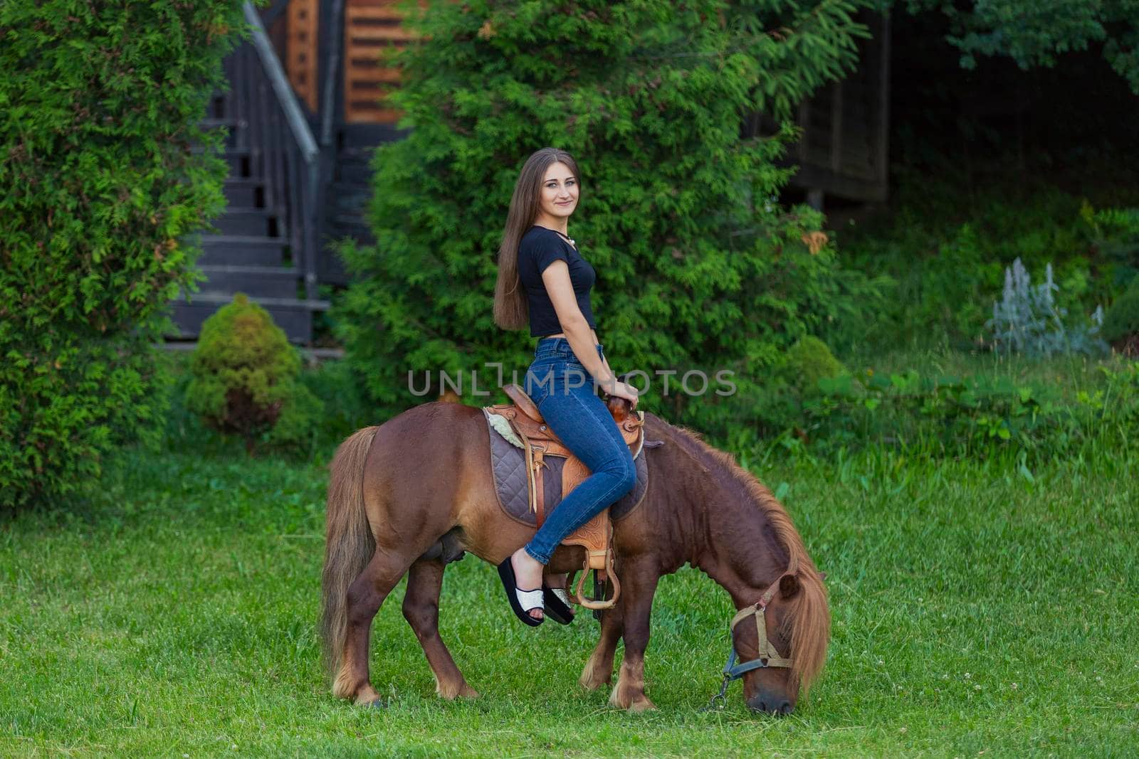 woman riding a pony on the lawn