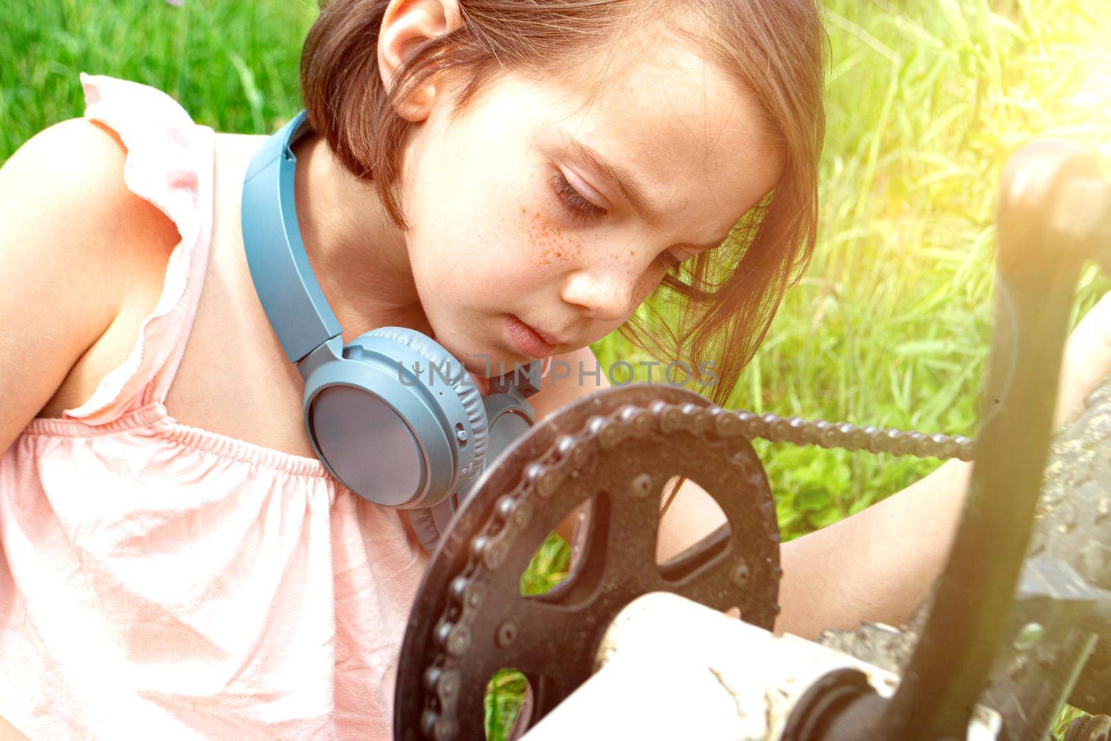 a child girl has damaged a bicycle wheel and is making repairs photo without processing. High quality photo