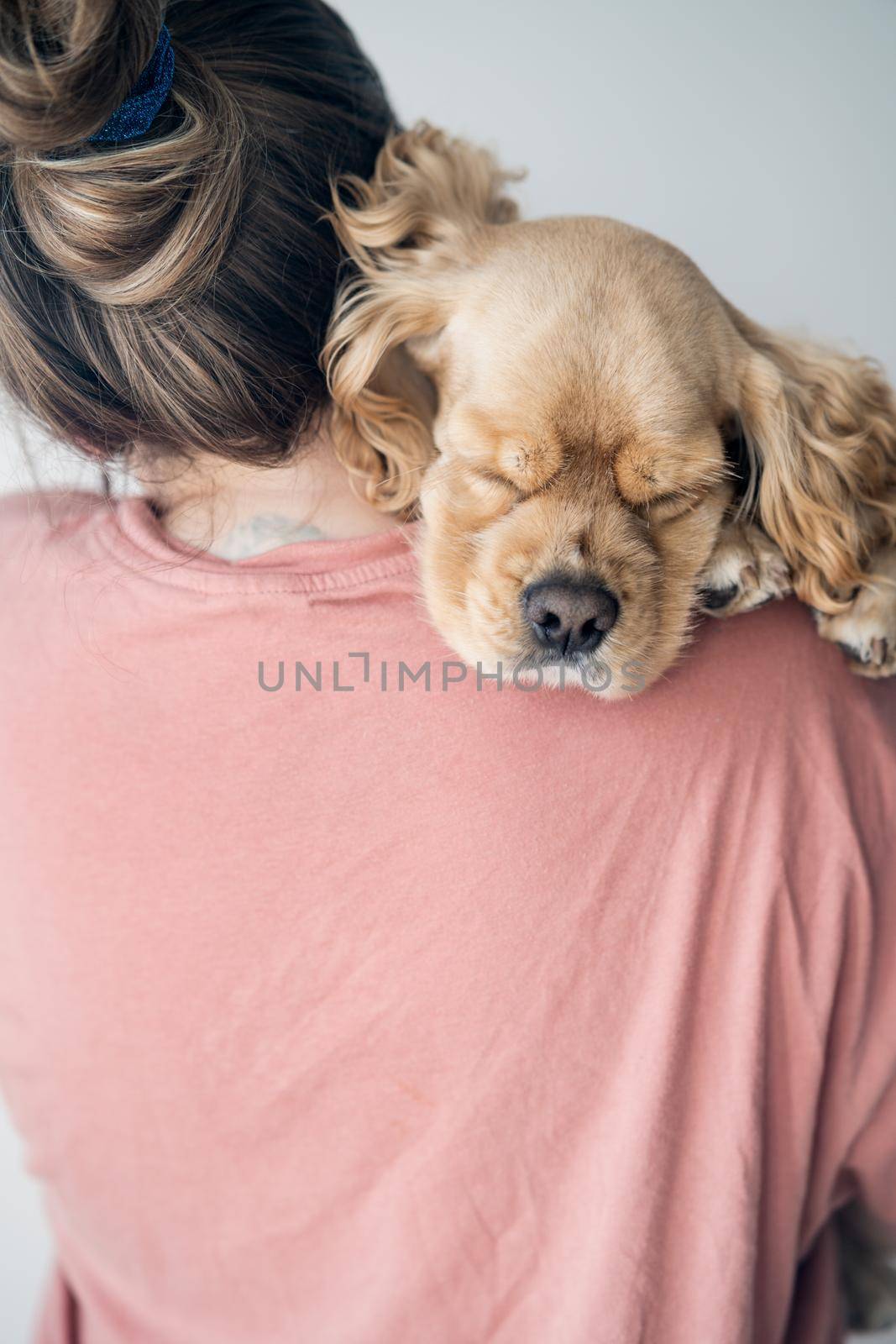 Young woman hugs her dog. The dog lies on the shoulder at a young woman. High quality photo