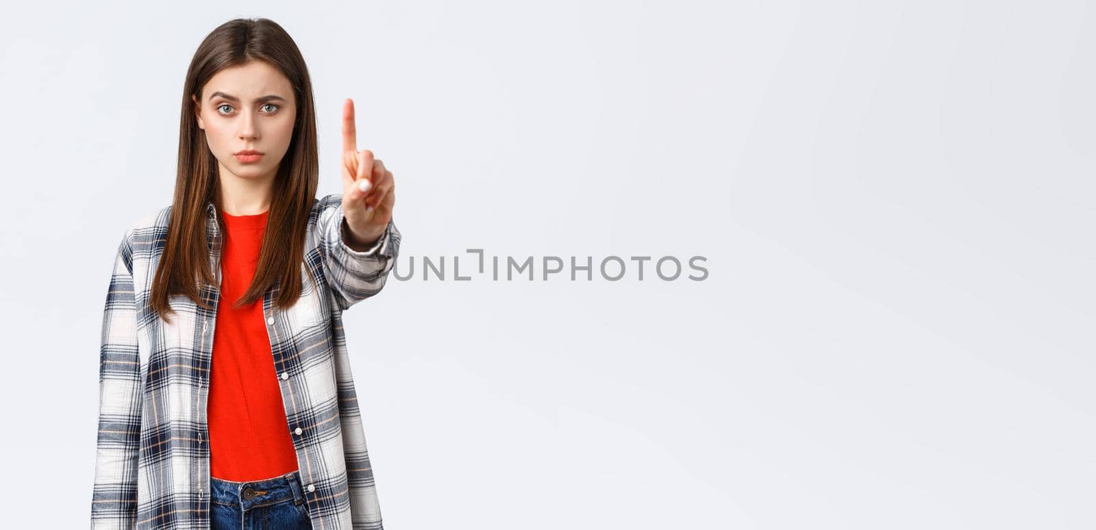 Lifestyle, different emotions, leisure activities concept. Serious concerned young woman showing index finger, scolding someone, tell to stop, warn or prohibit action, restrict from bad decision by Benzoix