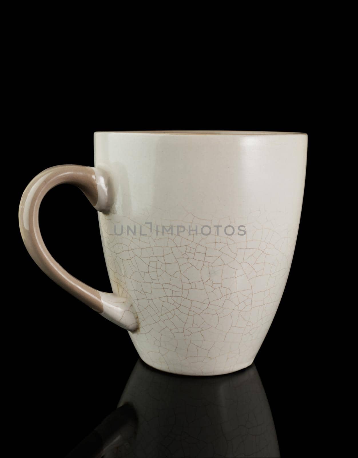 Mug with cracked walls, on a black background with reflection