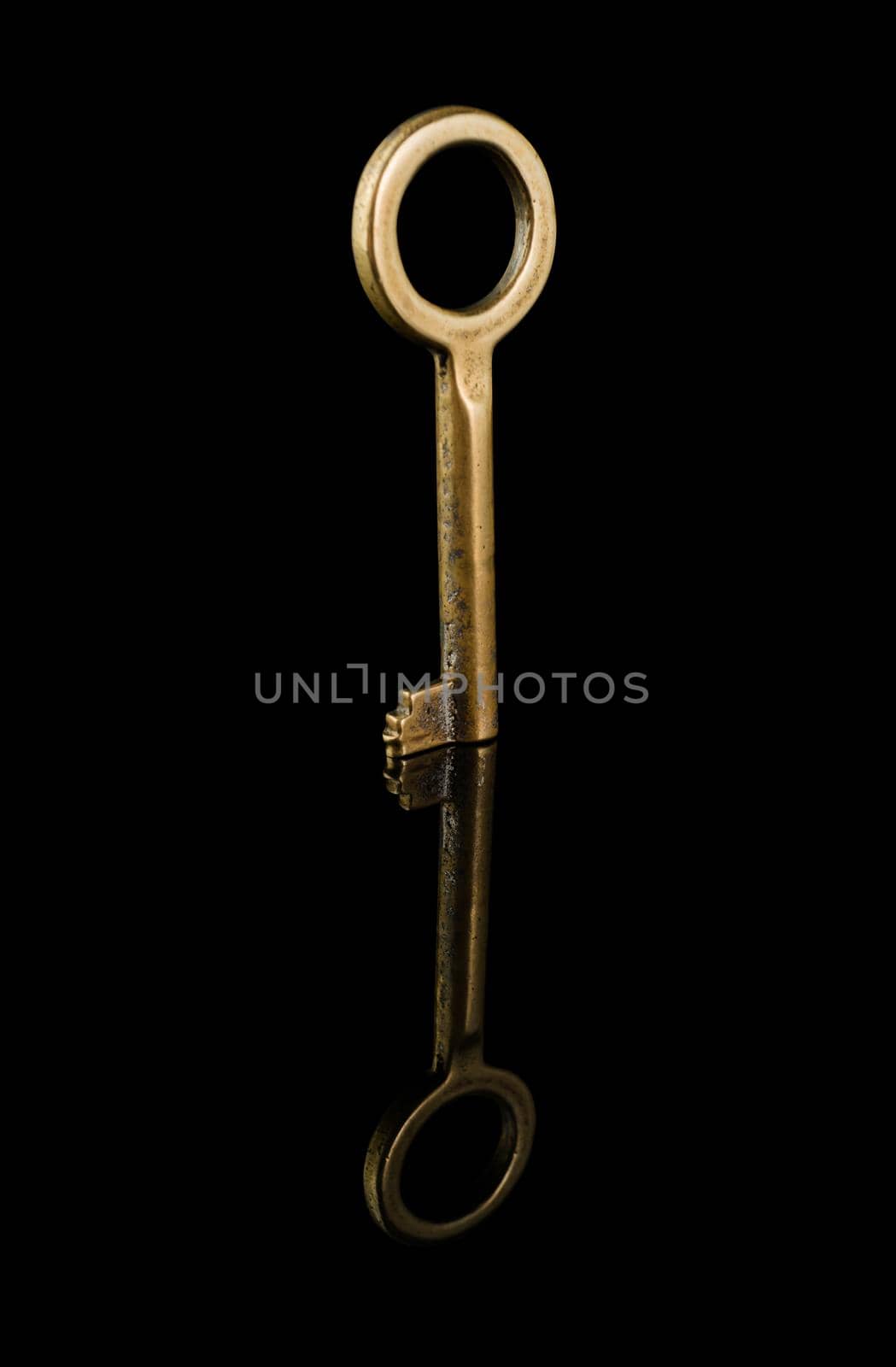 Old key, close up, on a black background isolated, with reflection