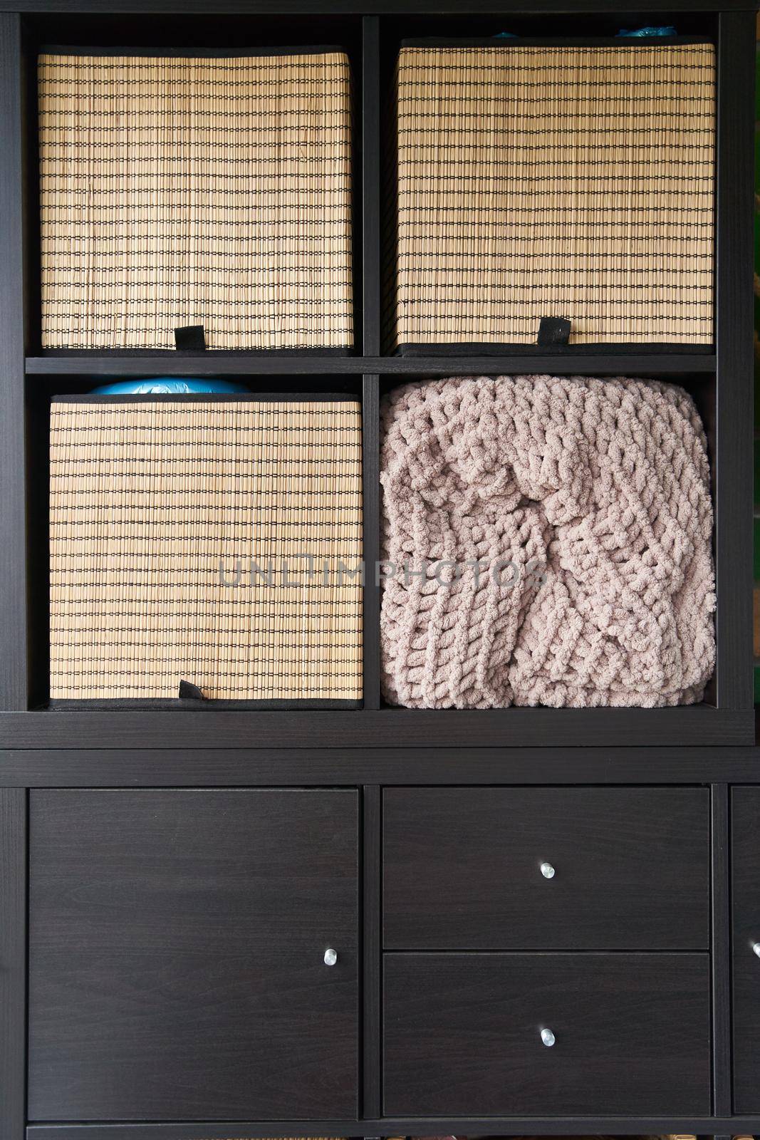 Wicker boxes for things on the shelves. Wardrobe for storage of things. High quality photo
