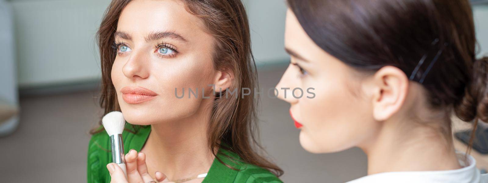 Make up artist applying professional make up of tonal foundation by okskukuruza