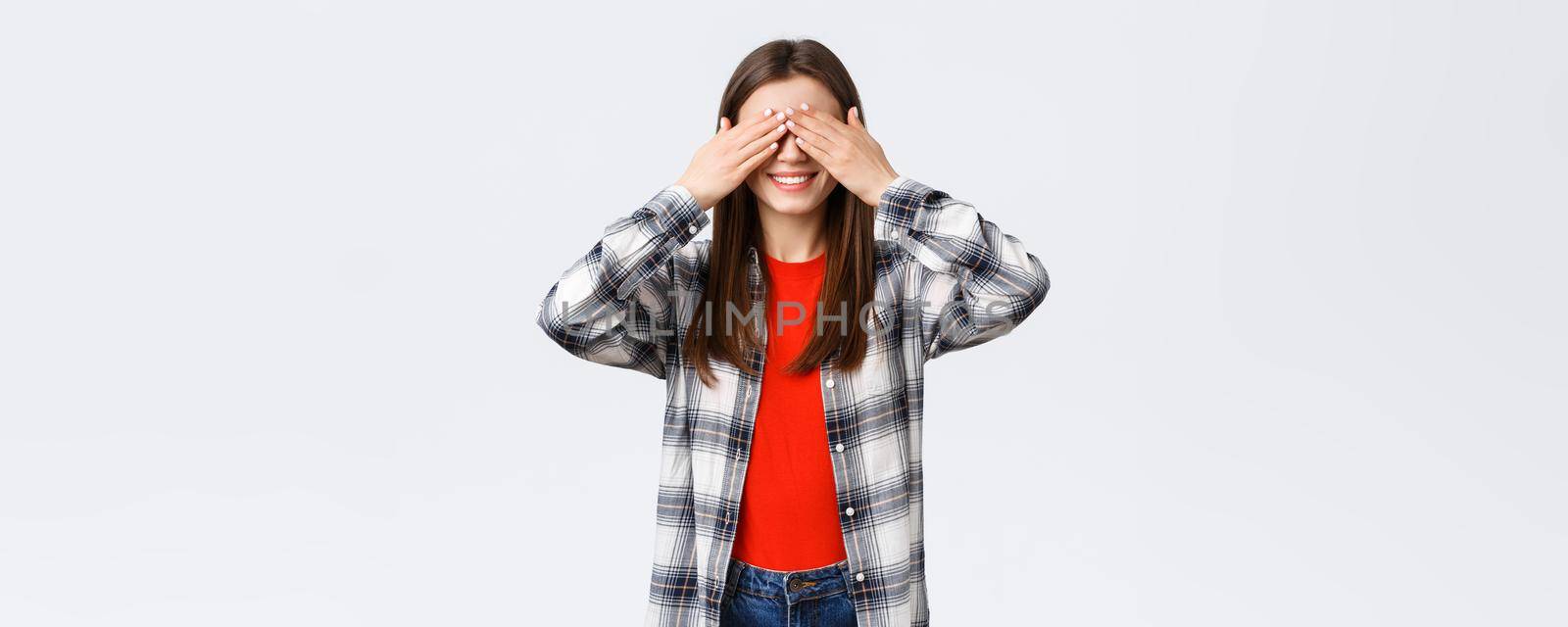 Lifestyle, different emotions, leisure activities concept. Excited happy young relaxed girl promise not peek. Woman cover eyes with palms, playing hide n seek or waiting for surprise.