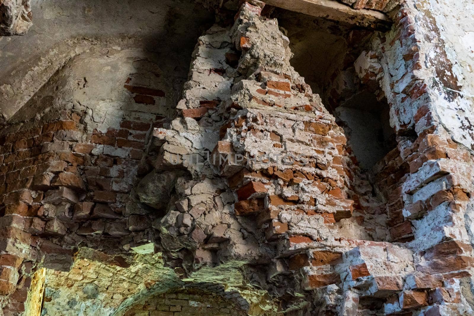 Destroyed wall of an ancient building built of red brick.