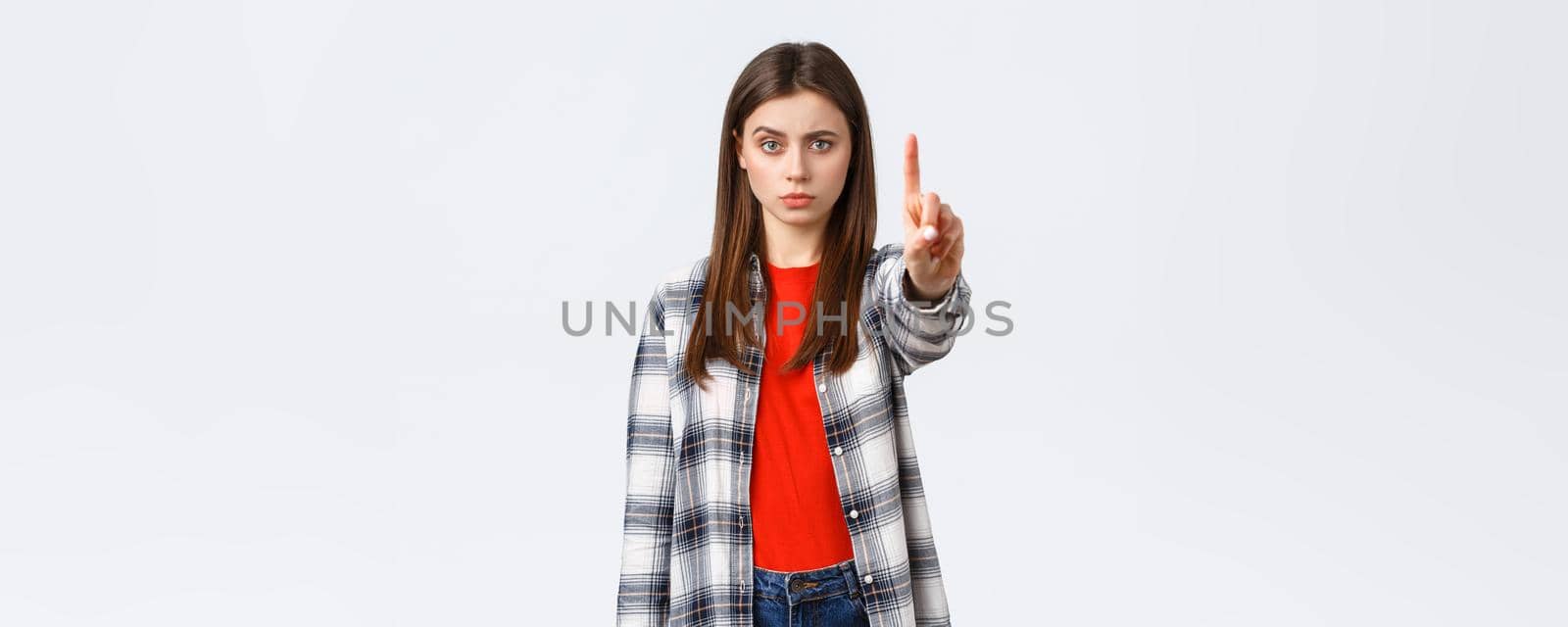 Lifestyle, different emotions, leisure activities concept. Serious concerned young woman showing index finger, scolding someone, tell to stop, warn or prohibit action, restrict from bad decision.