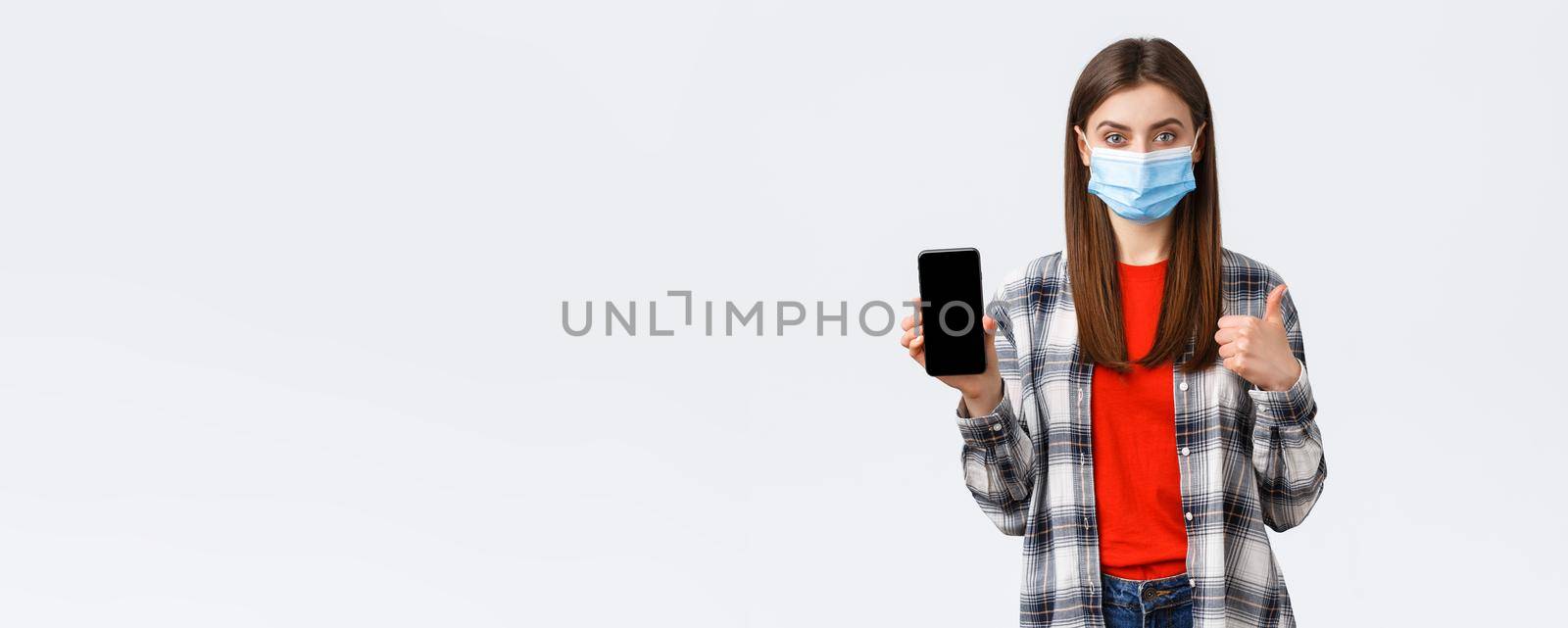 Different emotions, covid-19, social distancing and technology concept. Satisfied young confident girl recommend application, shopping site, show mobile phone screen and thumbs-up by Benzoix