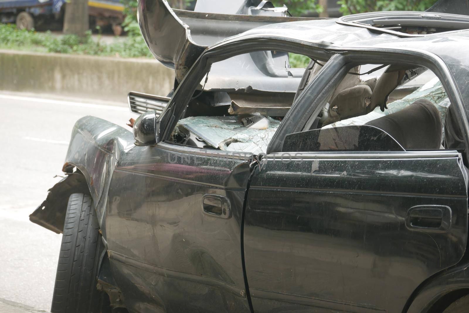 black car damaged by a road accident .
