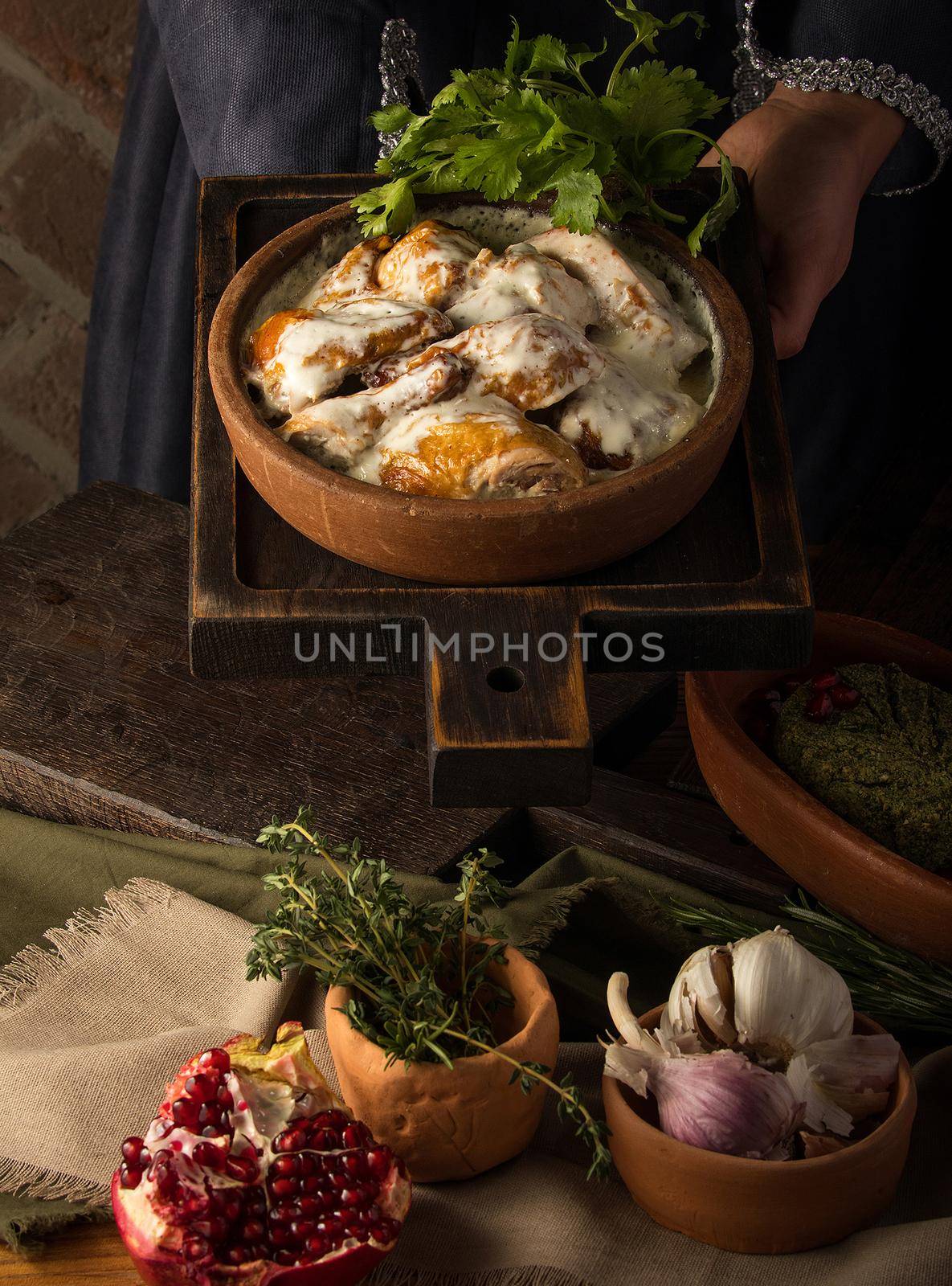 Vertical shot of a waitress presenting a chicken covered in a creamy sauce by A_Karim