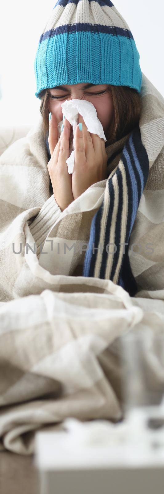 Portrait of sick woman blowing running nose and sneezing in tissue at home. Female having allergy symptoms coughing and fever. Health, isolation concept