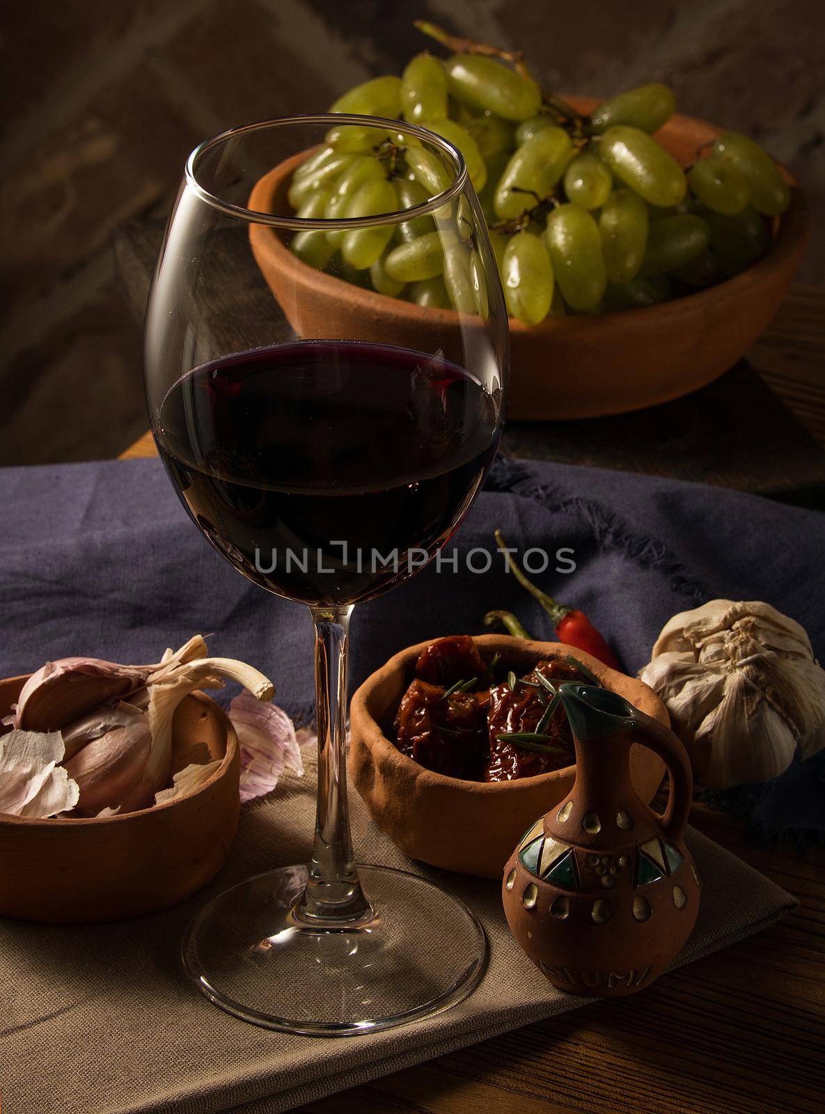 A glass of wine on a table with dishes