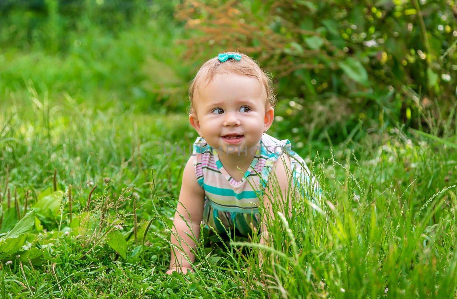 Baby is sitting on the grass. Selective focus. Nature.