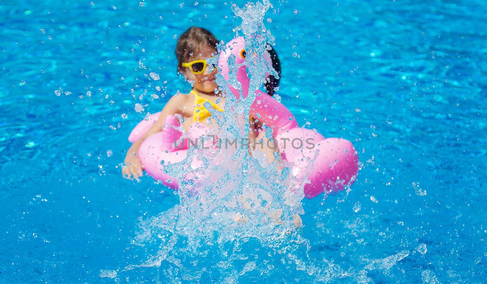 The child swims with a circle in the pool. Selective focus. Kid.