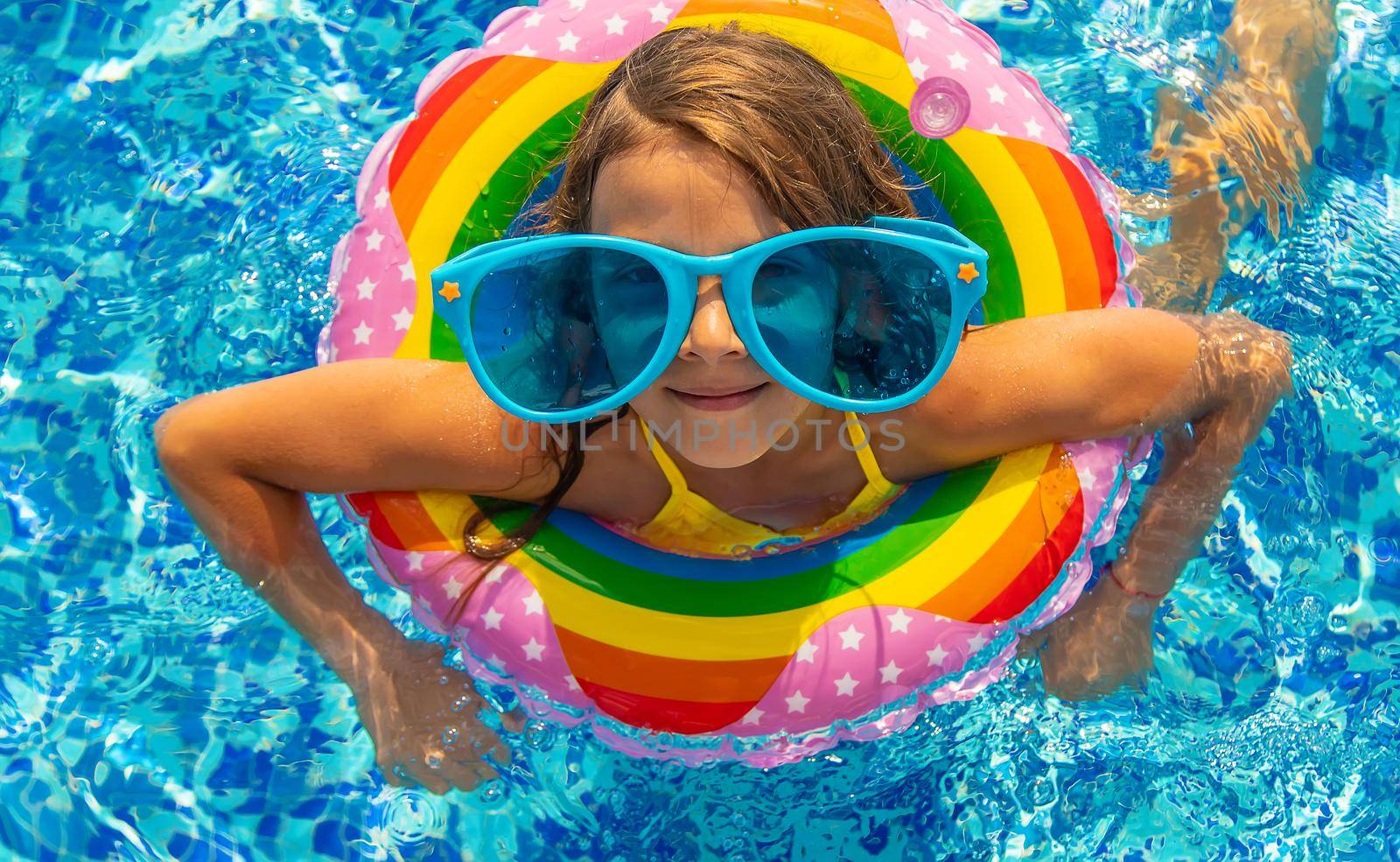 The child is swimming in the pool. Selective focus. Kid.