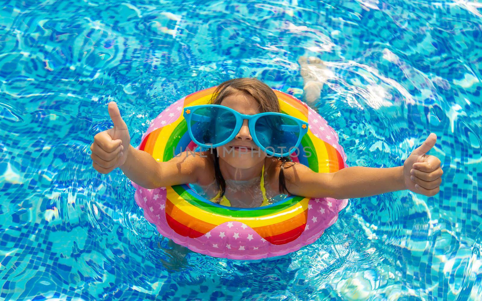 The child is swimming in the pool. Selective focus. Kid.