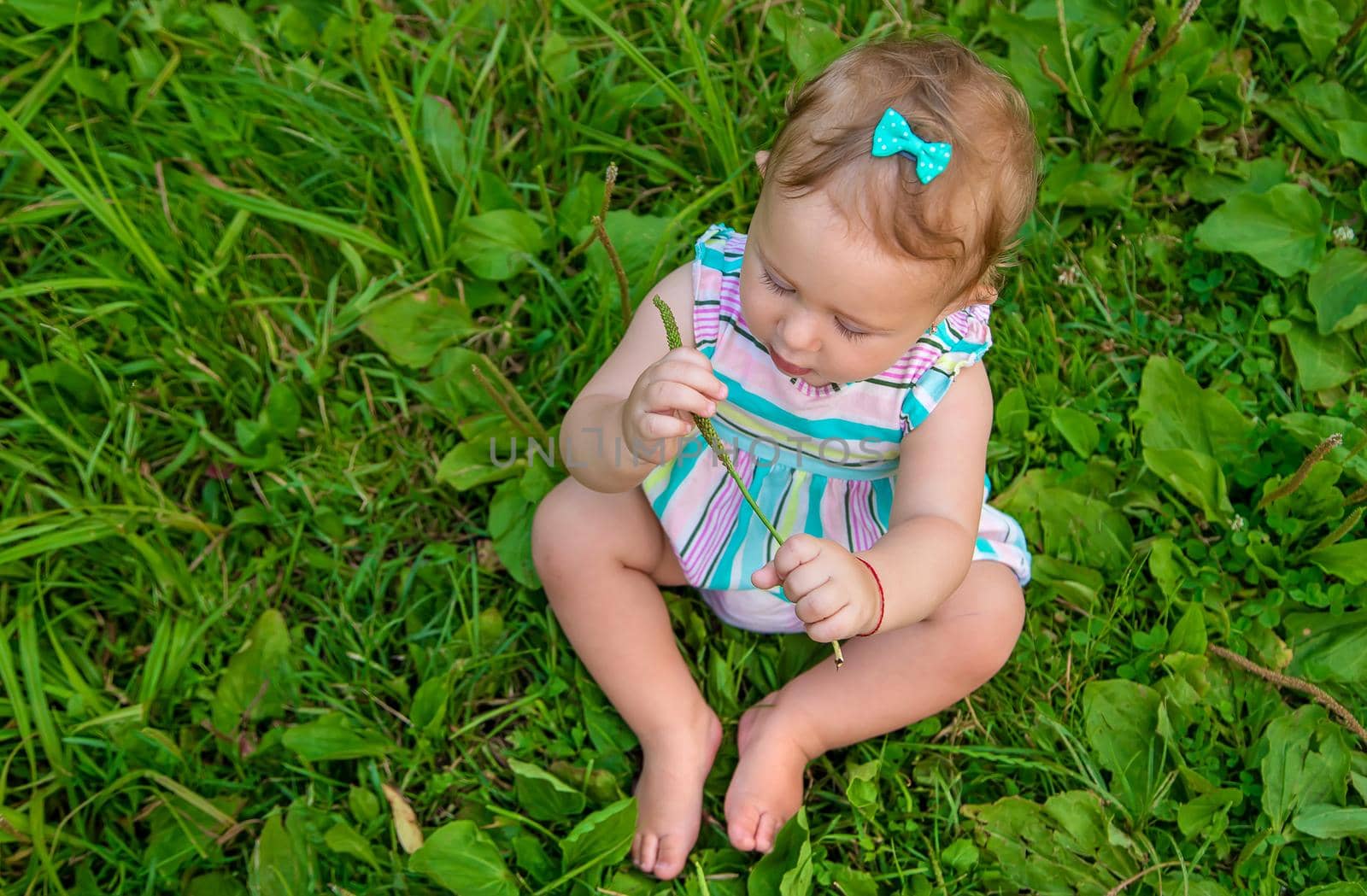 Baby is sitting on the grass. Selective focus. Nature.