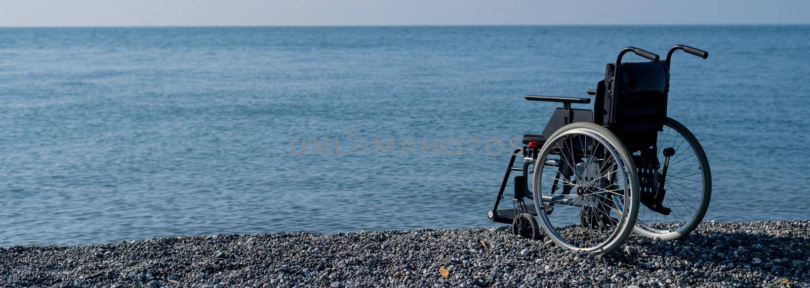 An empty wheelchair on a rocky seashore