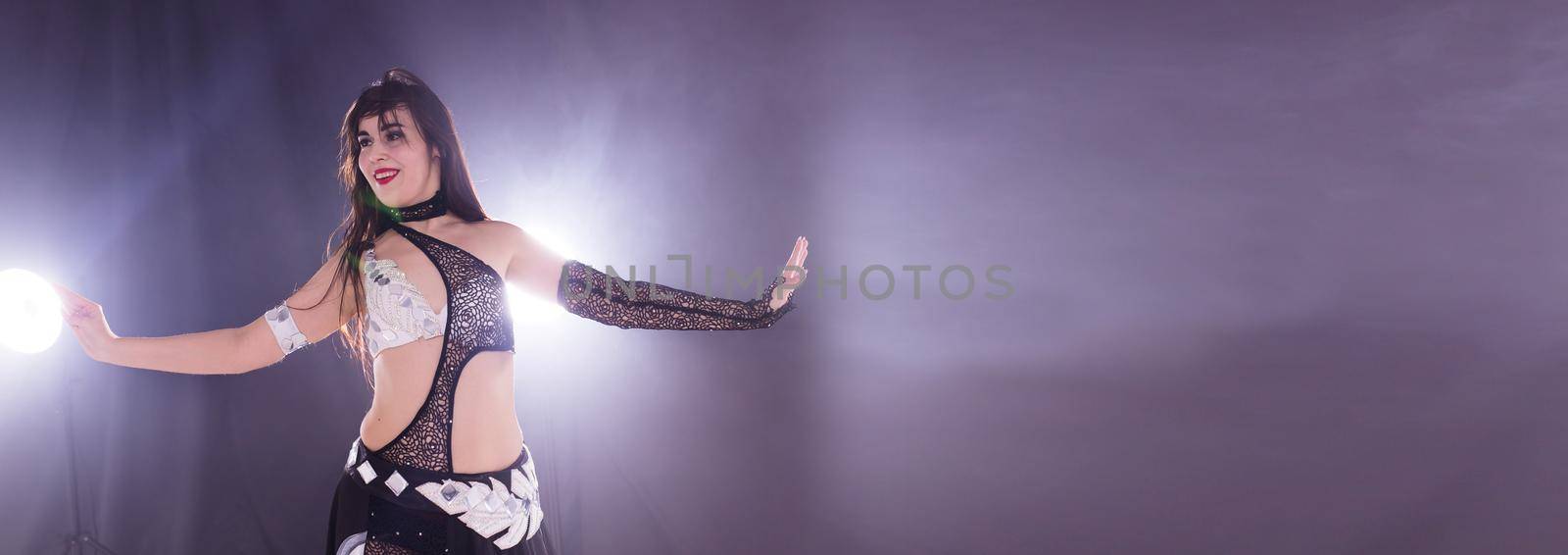 Banner portrait of a woman in oriental costume performing belly dance copy space. Tribal fusion dance concept. by Satura86