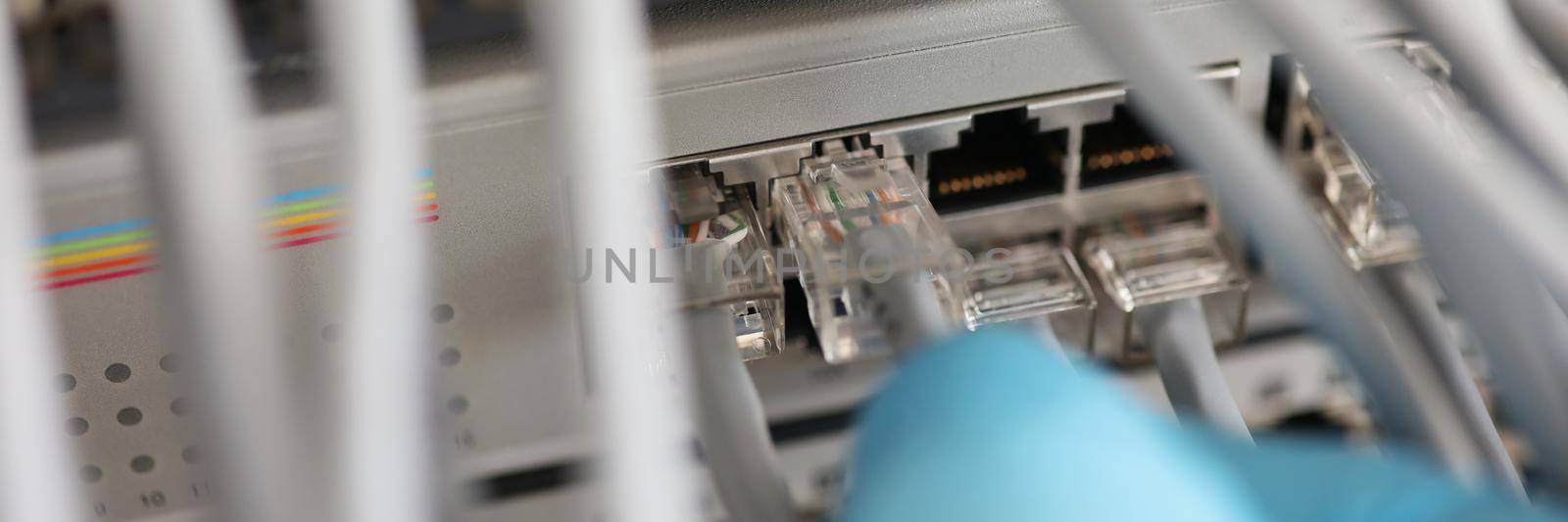 Close-up of technician hand connect switch ethernet cables and port to internet switch. Patch panel in data server room. Information technology concept