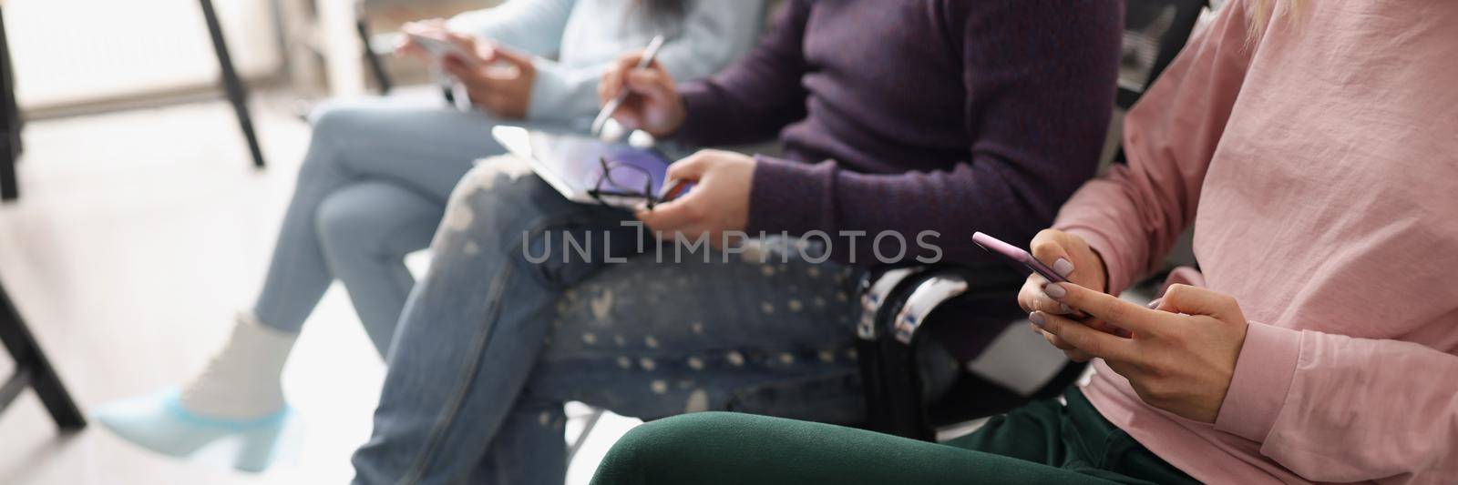 People sitting in line and surfing gadgets by kuprevich