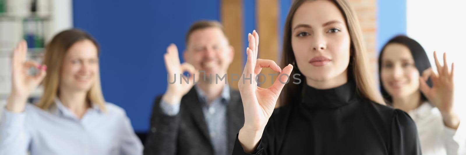 Portrait of coworkers showing ok gesture with hands good teamwork and successful work. Happy colleagues follow boss example. Business, achievement concept