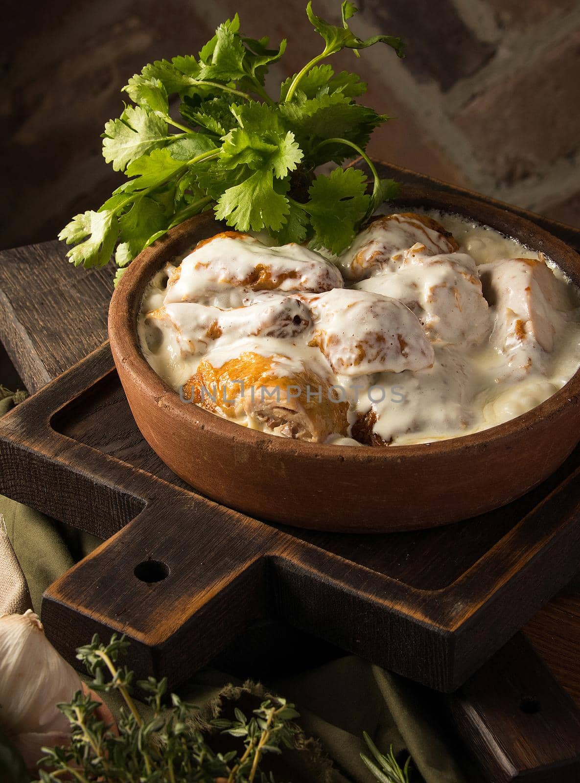 A vertical shot of a chicken covered in a creamy sauce