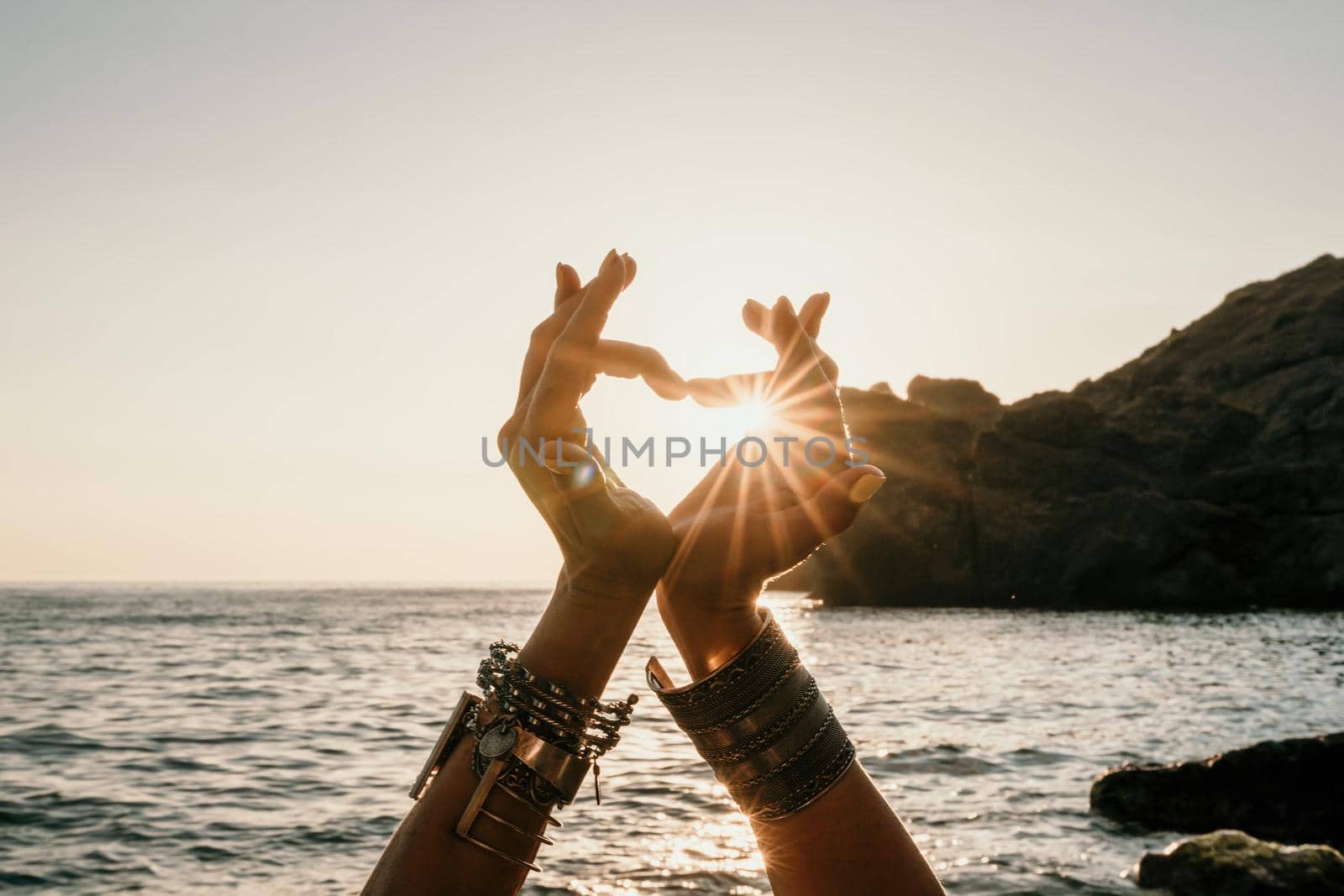 Young woman in swimsuit with long hair practicing stretching outdoors on yoga mat by the sea on a sunny day. Women's yoga fitness pilates routine. Healthy lifestyle, harmony and meditation concept.