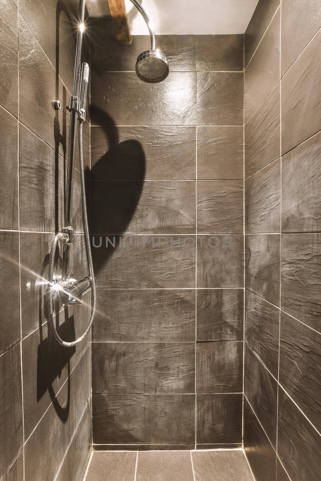 Modern styled shower cabinet with black tiled walls