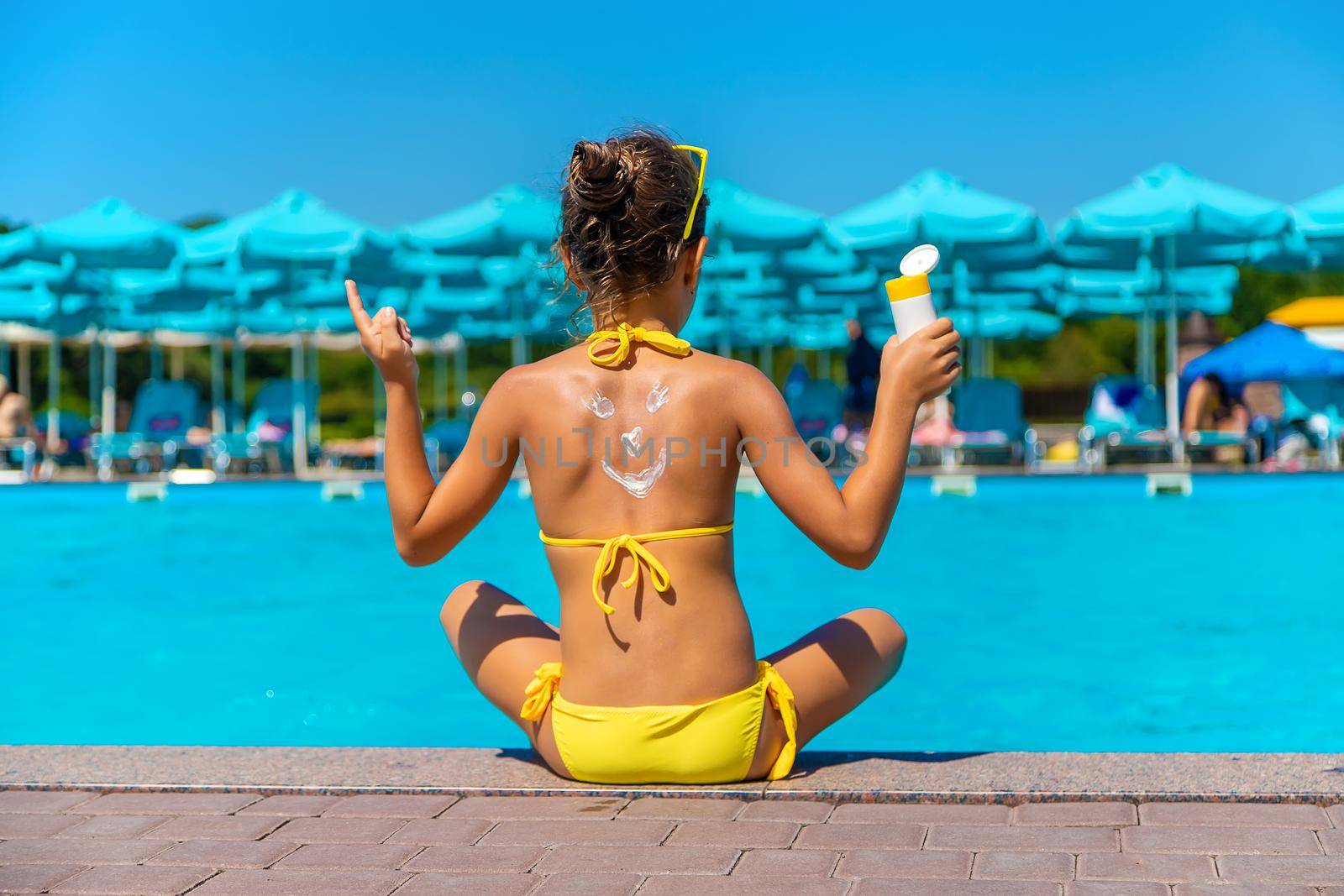 Sunscreen on the back of the child. Selective focus. Kid.